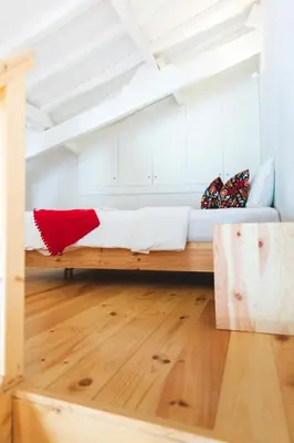 a room with a bed in the middle of a room at Aposentus -Romantic Mezzanine Apartment With a Balcony in Porto