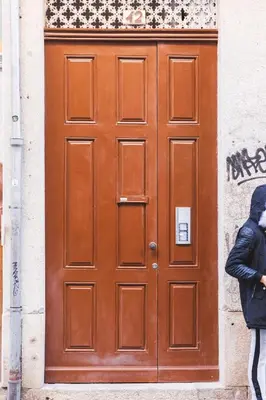 a person standing in front of a large wooden door at Aposentus -Romantic Mezzanine Apartment With a Balcony in Porto