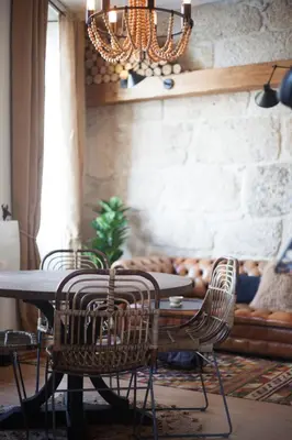 a dining room with a table and chairs and a chandelier at Little Capeli in Porto
