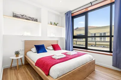 a bedroom with a bed and a large window at Porto Belo Bolhao Apartments - Free Parking in Porto