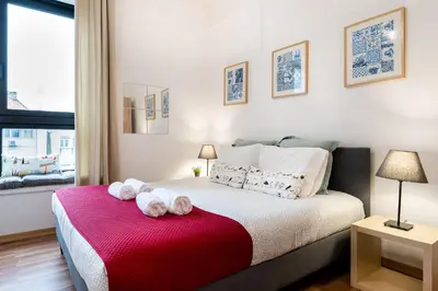 a bedroom with a bed with towels on a red blanket at Porto Belo Bolhao Apartments - Free Parking in Porto