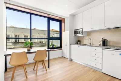 a kitchen with white cabinets and a large window at Porto Belo Bolhao Apartments - Free Parking in Porto