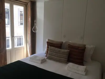 a bedroom with a bed with pillows and a window at Casas das Caldeiras in Porto