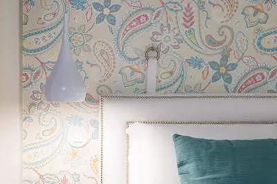 a bedroom with a wall with a floral wallpaper at Casas das Caldeiras in Porto
