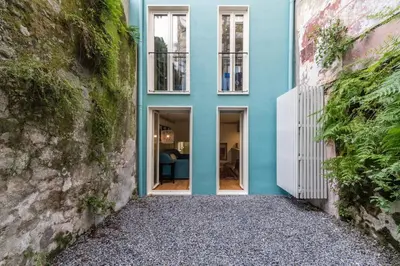 a blue house with white windows and a stone driveway at Casas das Caldeiras in Porto