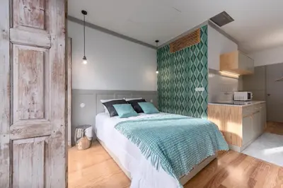 a bedroom with a bed with a green accent wall at Casas das Caldeiras in Porto