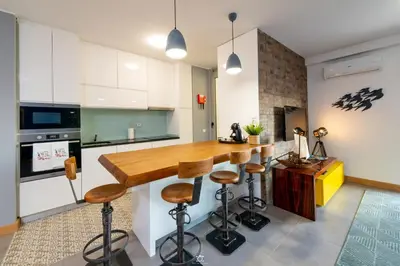 a kitchen with a wooden counter and stools at Porto Cathedral in Porto