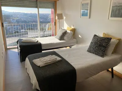 a room with two beds and a large window at Porto Cathedral in Porto