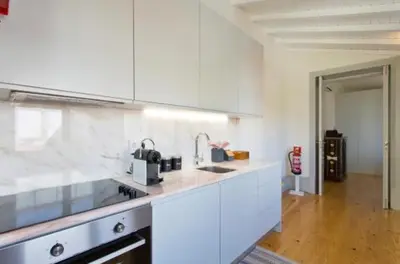 a kitchen with white cabinets and a counter top at A da Maria Ildefonso in Porto