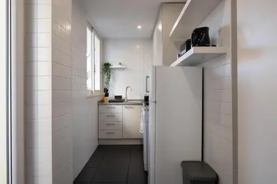 a small kitchen with a refrigerator and a sink at Poveiros Terrace - 3BR Downtown apartment with AC in Porto