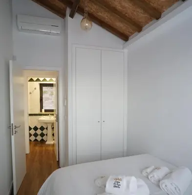 a bedroom with a bed with white sheets and towels at Modern house - air cond, free parking, breakfast, by Porto with Love LDA in Vila Nova de Gaia