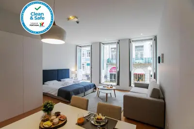 a living room with a bed and a dining room at Santa Catarina Downtown I in Porto
