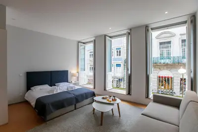 a bedroom with a bed and a couch and a table at Santa Catarina Downtown I in Porto