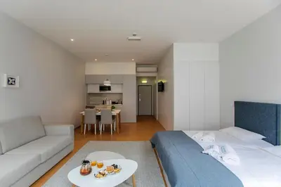 a bedroom with a bed and a couch and a table at Santa Catarina Downtown I in Porto