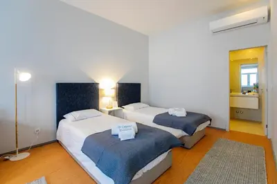 a bedroom with two beds and a bathroom at Santa Catarina Downtown II in Porto