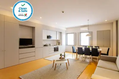 a living room with a couch and a table and a kitchen at Santa Catarina Downtown III in Porto