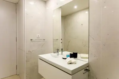 a white bathroom with a sink and a shower at Santa Catarina Downtown III in Porto