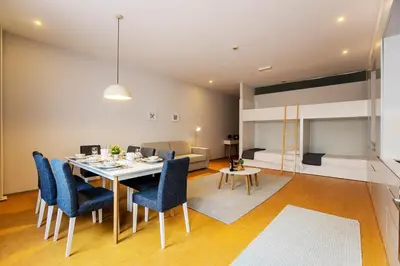 a dining room with a table and chairs and a bedroom at Santa Catarina Downtown III in Porto