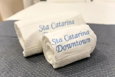 a stack of towels sitting on top of a bed at Santa Catarina Downtown III in Porto