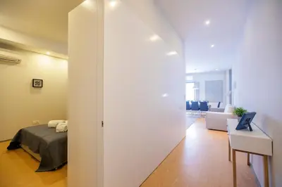 a room with a bed and a white wall at Santa Catarina Downtown III in Porto