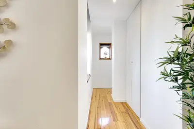 a hallway with white walls and wooden floors and plants at January's 31 Studio by DA'HOME in Porto