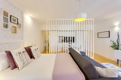 a bedroom with a large white bed and a couch at January's 31 Studio by DA'HOME in Porto