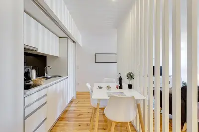 a kitchen and dining room with a white table and chairs at January's 31 Studio by DA'HOME in Porto