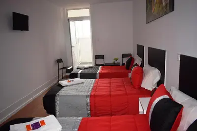 a hotel room with two beds and a couch at Guest House Henrique VIII in Porto