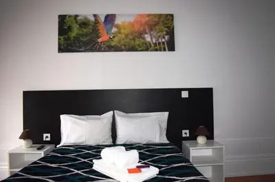 a bedroom with a bed with two towels on it at Guest House Henrique VIII in Porto