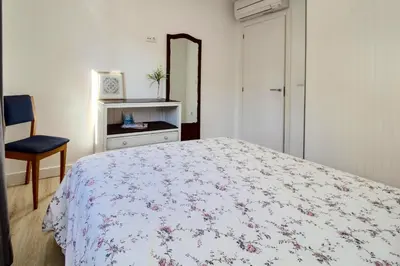 a bedroom with a bed and a mirror and a chair at Casa de Gaia in Vila Nova de Gaia