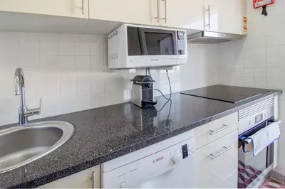 a kitchen with a sink and a microwave at Casa de Gaia in Vila Nova de Gaia