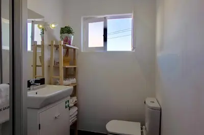 a bathroom with a sink and a toilet and a window at Casa de Gaia in Vila Nova de Gaia