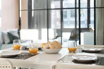 a table with a bowl of bread and two glasses of orange juice at LovelyStay - Wohaza Apartment with free private parking in Porto