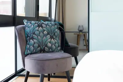 a chair with a pillow in a room with windows at LovelyStay - Wohaza Apartment with free private parking in Porto