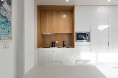 a kitchen with white cabinets and a table and chairs at LovelyStay - Wohaza Apartment with free private parking in Porto