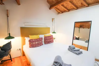a bedroom with a white bed and a mirror at Macário Cosy Loft in Porto