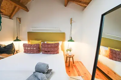 a bedroom with a large white bed with colorful pillows at Macário Cosy Loft in Porto