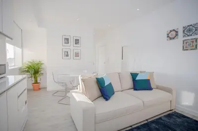 a white living room with a white couch with pillows at Liiiving in Porto | Center Spot Apartment in Porto