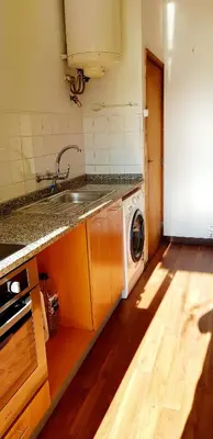 a kitchen with a sink and a washing machine at City Heart Rooms in Porto