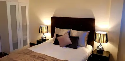 a bedroom with a bed with pillows and two lamps at City Heart Rooms in Porto