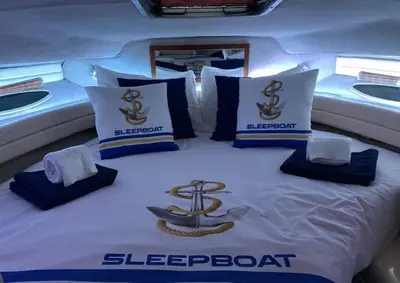 a bed in the middle of a boat withigerboardvertisements at SLEEPBOAT Barco Hotel in Porto
