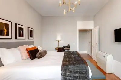 a bedroom with a white bed and a chandelier at The White Box Boutique House in Porto