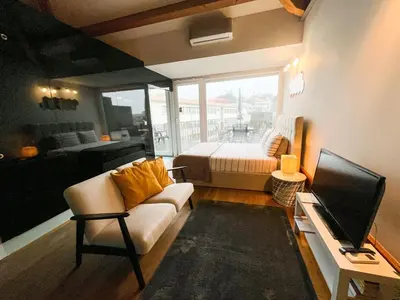 a living room with a couch and a bed and a television at NiP Apartment | Porto City Center Near All Sights in Porto