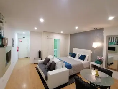a bedroom with a bed and a couch and a table at Be Happy in Porto in Porto