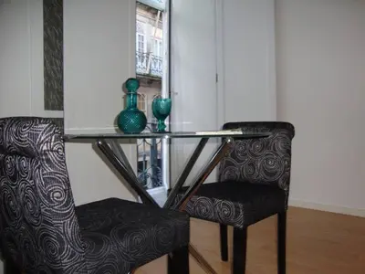 a table with two chairs and a glass table with a vase at Be Happy in Porto in Porto