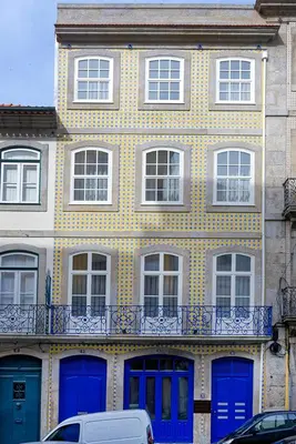 a yellow and blue building with blue doors and windows at Mayor's Apartments in Porto