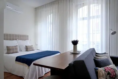 a bedroom with a bed and a table and a couch at Mayor's Apartments in Porto
