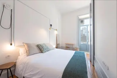 a bedroom with a large bed and a window at Tripas-Coração, Sá da Bandeira in Porto