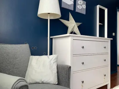 a blue bedroom with a white dresser and a chair at SP199 Flat in Porto