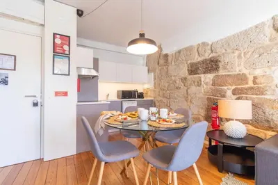 a bedroom with a large bed and a stone wall at LovelyStay - Sao Domingos Apartment in Porto